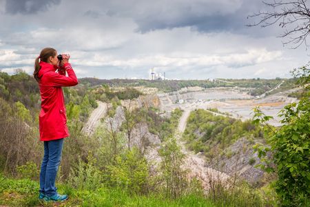 Frau schaut mit Fernglas beim Museumspark Rüdersdorf in die Weite